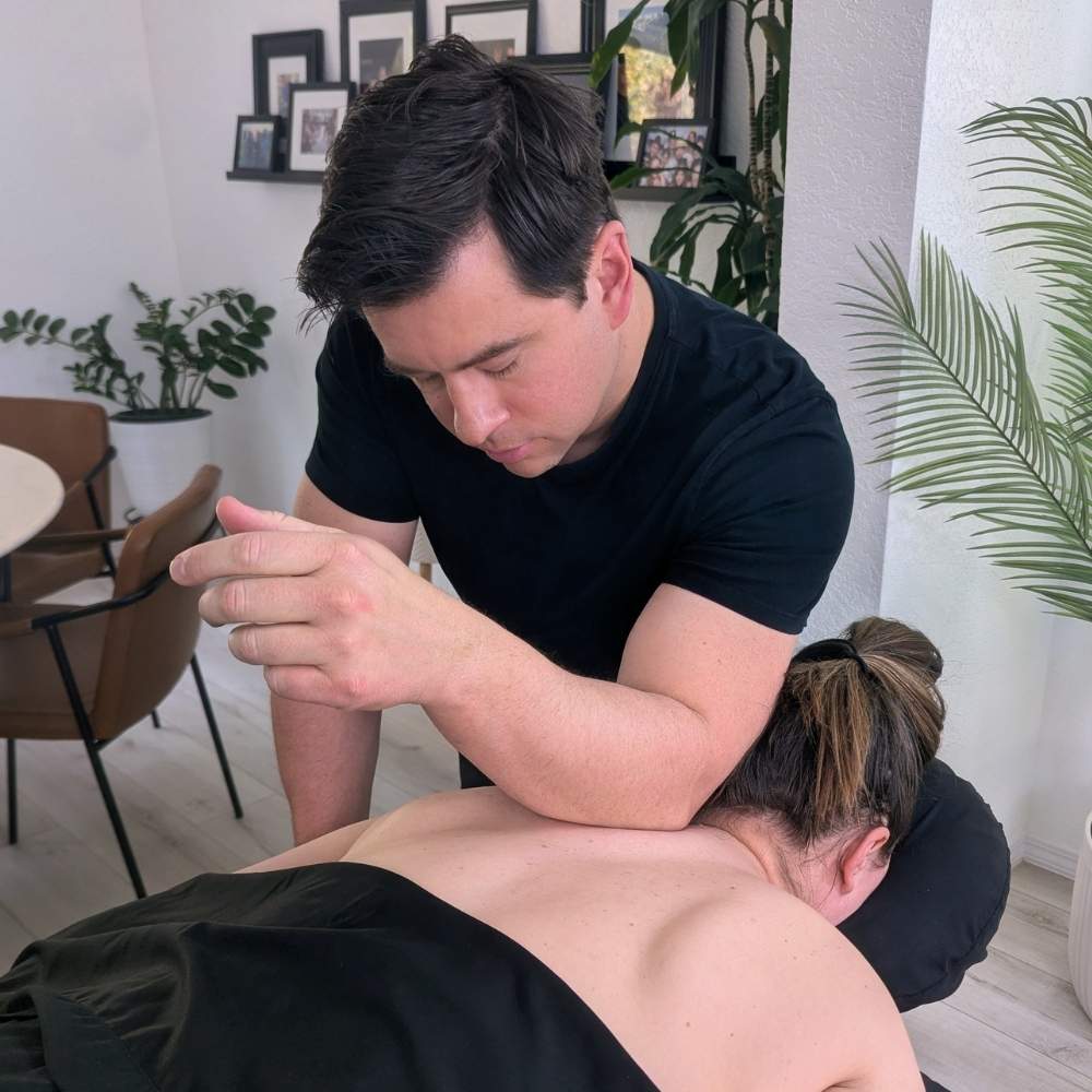 Redmond client receiving in-home physical rehab and deep tissue trapezius and upper back work on a mobile massage table.
